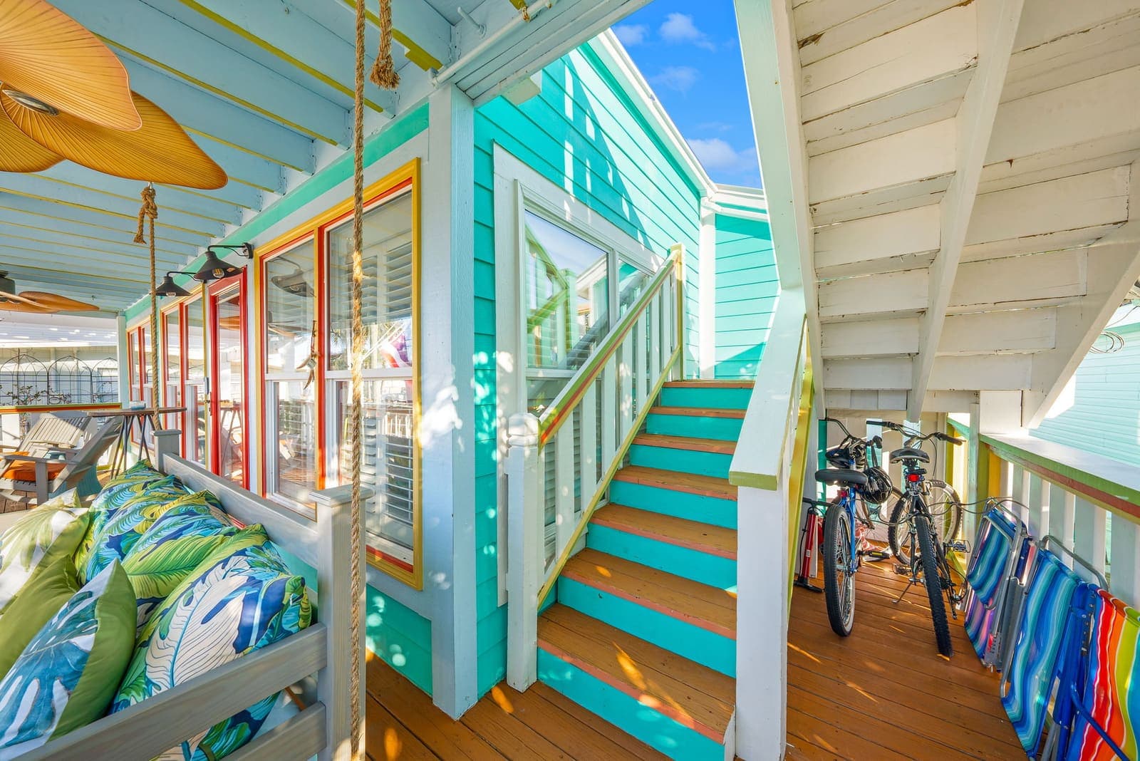 Teal staircase with guest bikes below the porch